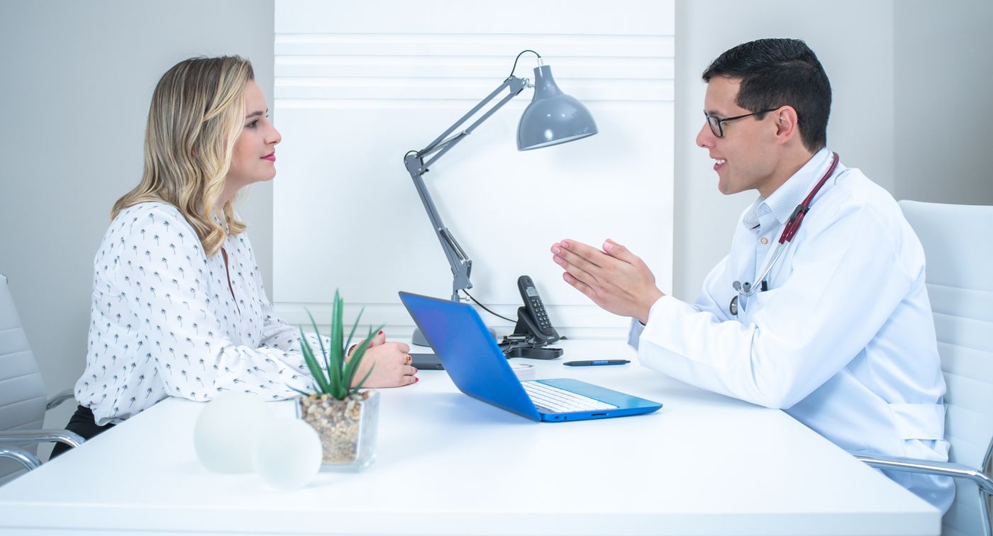 A specialist in a consultation with a client, discussing a health plan across a desk